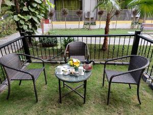 2 chaises et une table avec des tasses et des fleurs. dans l'établissement Kyriad Prestige Calangute Goa by OTHPL, à Calangute