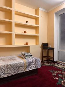 a bedroom with shelves and a bed and a desk at СОФЬЯ ГОСТЕВОЙ ДОМ in Bukhara