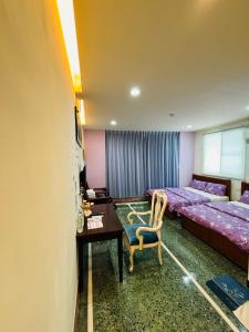 Xingang的住宿－新港風情民宿，一间卧室配有两张床、一张桌子和一张桌子