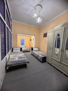 una camera con tre letti in una stanza con di СОФЬЯ ГОСТЕВОЙ ДОМ a Bukhara