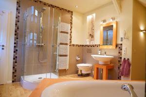 een badkamer met een bad, een wastafel en een douche bij Ferienwohnung für vier Personen - b56325 in Olsberg