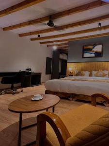 a bedroom with a bed and a table and a couch at Eden Resort Nubra in Hundar