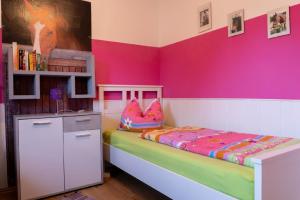 1 dormitorio con 1 cama con pared de color rosa en Ferienwohnung mit Balkon und zwei Schlafzimmern en Weißenstadt