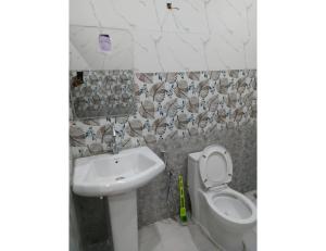 y baño con lavabo y aseo. en Rishi Dhara Resort and Cottages, Barkot, en Barkot