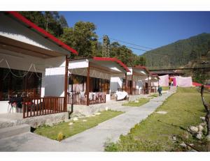 una fila de edificios con mesas y sillas en una calle en Rishi Dhara Resort and Cottages, Barkot, en Barkot