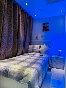 1 dormitorio con 1 cama con iluminación azul en DSV Property en Abu Dabi