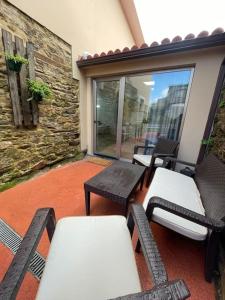 a patio with two benches and a table and chairs at Apartamento Casa Cesárea in Cedeira