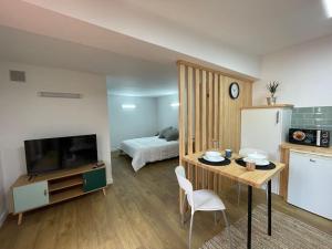 a kitchen and living room with a table and a television at Apartamento Casa Cesárea in Cedeira