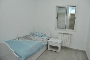 um pequeno quarto com uma cama e uma janela em VILLA DE LUXE KANTAOUI SOUSSE em Hammam Sousse