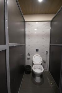 a small bathroom with a toilet in a stall at Hostells in Pune