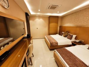 卡爾巴拉的住宿－King Hotel Karbala，酒店客房设有两张床和一台平面电视。