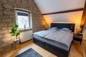 a bedroom with a bed and a stone wall at Lava-Lodge (Ferienhaus) in Rieden