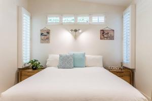 a bedroom with a white bed and two windows at Villa Ohana Pono Luxury Family Home in Sunshine in Sunshine Beach +45 photos