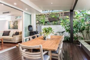a dining room with a wooden table and chairs at Villa Ohana Pono Luxury Family Home in Sunshine in Sunshine Beach