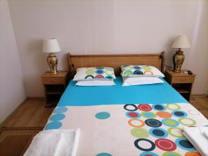 a bed in a room with two nightstands and a bed with a blue at Guesthouse Olimp in Sozopol