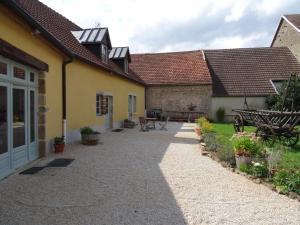 a courtyard of an old house with a patio at Datcha Bourguignonne, Chambres & Gîte in Maconge