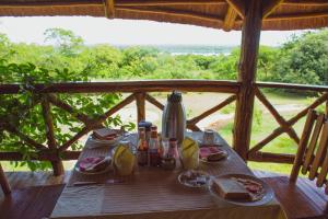 a wooden table with food and drinks on it at Elephant View Lodge in Kasenyi