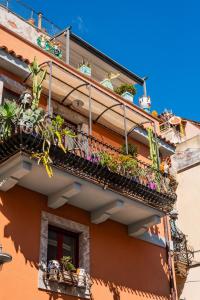 a balcony with potted plants on a building at Cascabella Taormina in Taormina