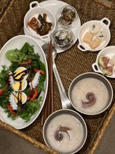 una mesa con platos de comida y tazones de comida en Stay Dooroo en Suncheon