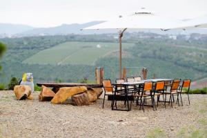 a table with chairs and an umbrella on a hill at KMI Homestay – Tea and Coffee in Di Linh