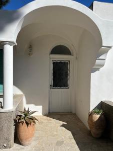 Casa blanca con puerta blanca y macetas en Casa Bella Capri, en Capri