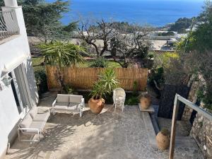 un patio con sillas, plantas y el océano en Casa Bella Capri, en Capri