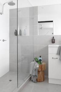 a bathroom with a shower stall and a sink at The Lodge Noosa ~ Coastal Luxe in Noosas Heart in Noosa Heads