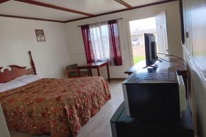 Schlafzimmer mit einem Bett und einem Schreibtisch mit einem Laptop in der Unterkunft Country Hearth Inn & Suites By OYO Sturgis in Sturgis