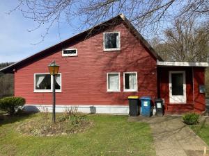 a red house with four trash cans in front of it at Lillebo in Lütjensee