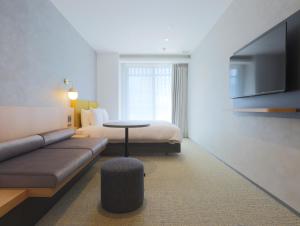 pokój hotelowy z kanapą i łóżkiem w obiekcie HOTEL Tomiya with M's w mieście Kioto