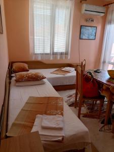 a room with two beds and a table and a desk at Guesthouse Olimp in Sozopol