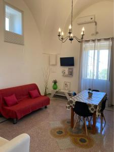 sala de estar con sofá rojo y mesa en THE OLD HOUSE 1926, en Uggiano la Chiesa