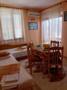 a dining room with a table and chairs and a bedroom at Guesthouse Olimp in Sozopol
