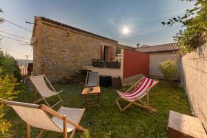 a yard with lawn chairs and a house at Istrian House La Bora in Koper