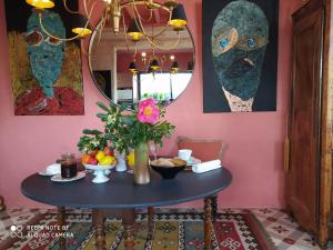 ein Esszimmer mit einem Tisch und einer Vase aus Blumen in der Unterkunft Suite dans Une Echoppe in Bègles