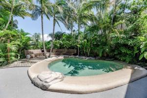 a swimming pool with a statue in the middle at The Rest Family Cottage with Resort Style Pool in Noosa Heads
