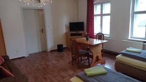 a living room with a table and a tv at Pension Sommer Locktow in Locktow