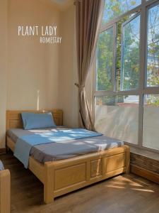 a bed in a room with a large window at Plant Lady Homestay Cao Bằng in Cao Bằng