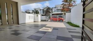 Un patio vacío con una valla y un coche rojo. en D'Aster Sara's Homestay Seremban NS, en Seremban
