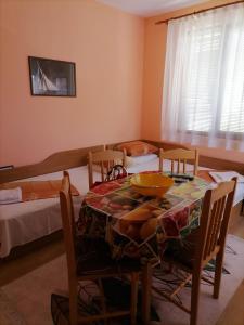 a dining room with a table and chairs and a bed at Guesthouse Olimp in Sozopol