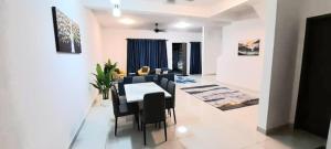 Un comedor y una sala de estar con mesa y sillas. en D'Aster Sara's Homestay Seremban NS, en Seremban