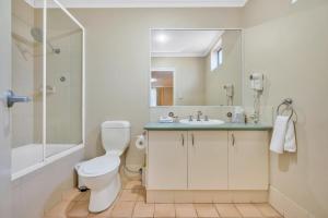 uma casa de banho com um WC, um lavatório e um chuveiro em C Mandurah Apartment Resort em Mandurah