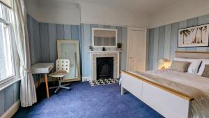 海丁利Spacious home, by Headingley Stadium, LGI, Leeds Arena, and the University of Leeds的一间卧室配有一张床、一张桌子和一个壁炉 更多29张照片