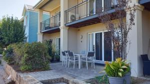 a patio with chairs and a table on a house at C Mandurah Apartment Resort in Mandurah