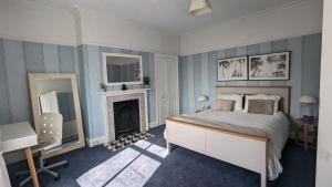 海丁利Spacious home, by Headingley Stadium, LGI, Leeds Arena, and the University of Leeds的一间卧室配有一张床、一张桌子和一个壁炉