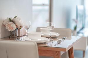 a table with plates and glasses and flowers on it at CBD Riverview 2B1B Apt w Shared Pool, Gym in Brisbane