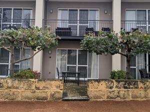 uma casa com duas árvores em frente em C Mandurah Apartment Resort em Mandurah