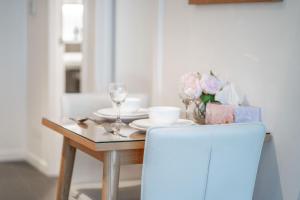 a dining room table with a blue chair and a table with glasses at CBD Riverview 2B1B Apt w Shared Pool, Gym in Brisbane