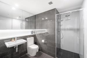a bathroom with a shower and a toilet and a sink at CBD Riverview 2B1B Apt w Shared Pool, Gym in Brisbane