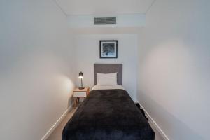 a bedroom with a bed in a white room at CBD Riverview 2B1B Apt w Shared Pool, Gym in Brisbane